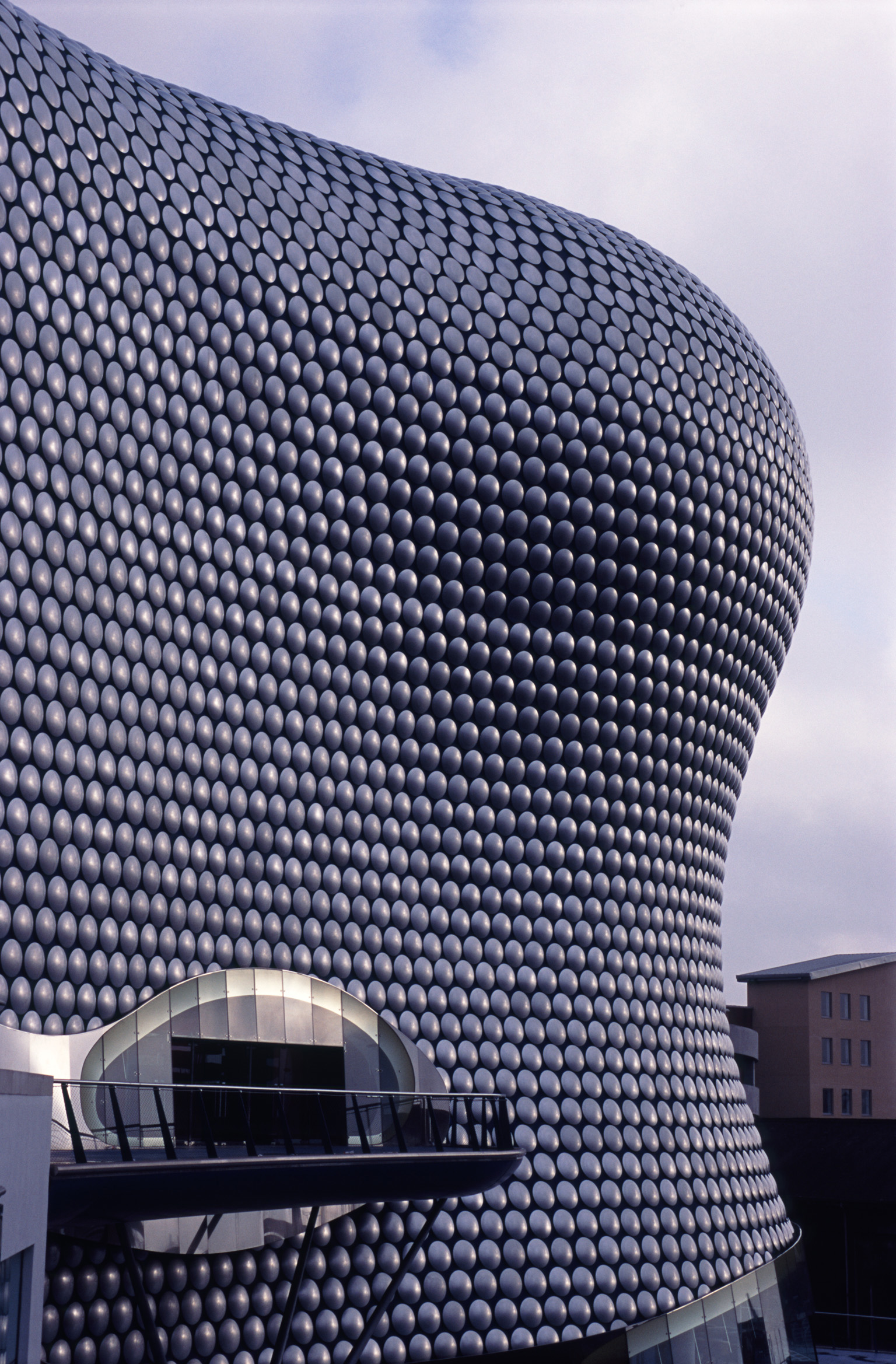 an image of Exterior facade of the Bullring Shopping Centre with its modern curved architectural design and entrance, Birmingham, UK