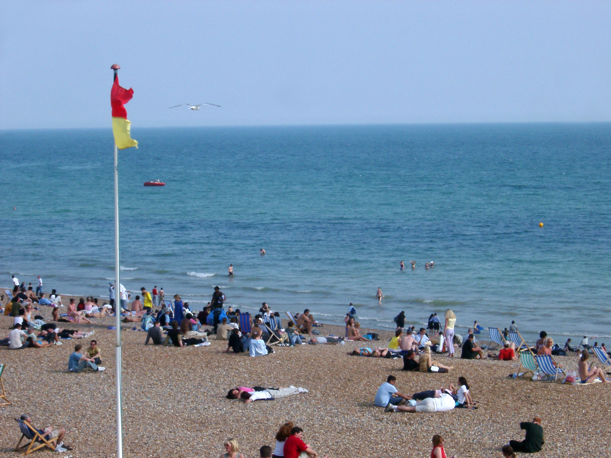 an image of Tourists Relaxing at Beautiful Brighton Beach in England.