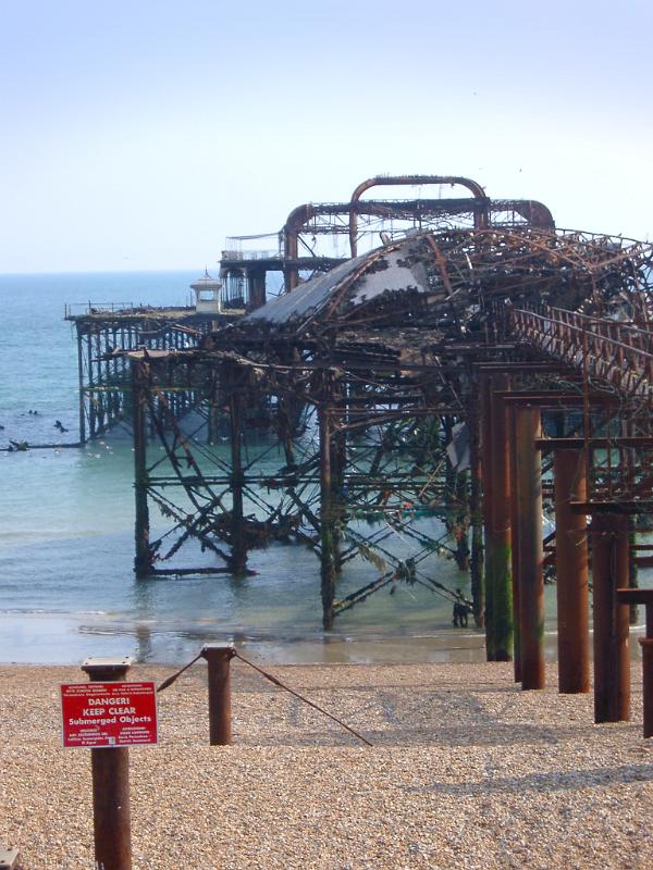 Fire damaged ruins and mangled warped iron structure of the old Brighton Pier , a Victorian landmark