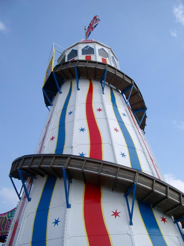 Looking up the tower from below at a colorful helter skelter ride for kids in an amusement park with red and blue decoration