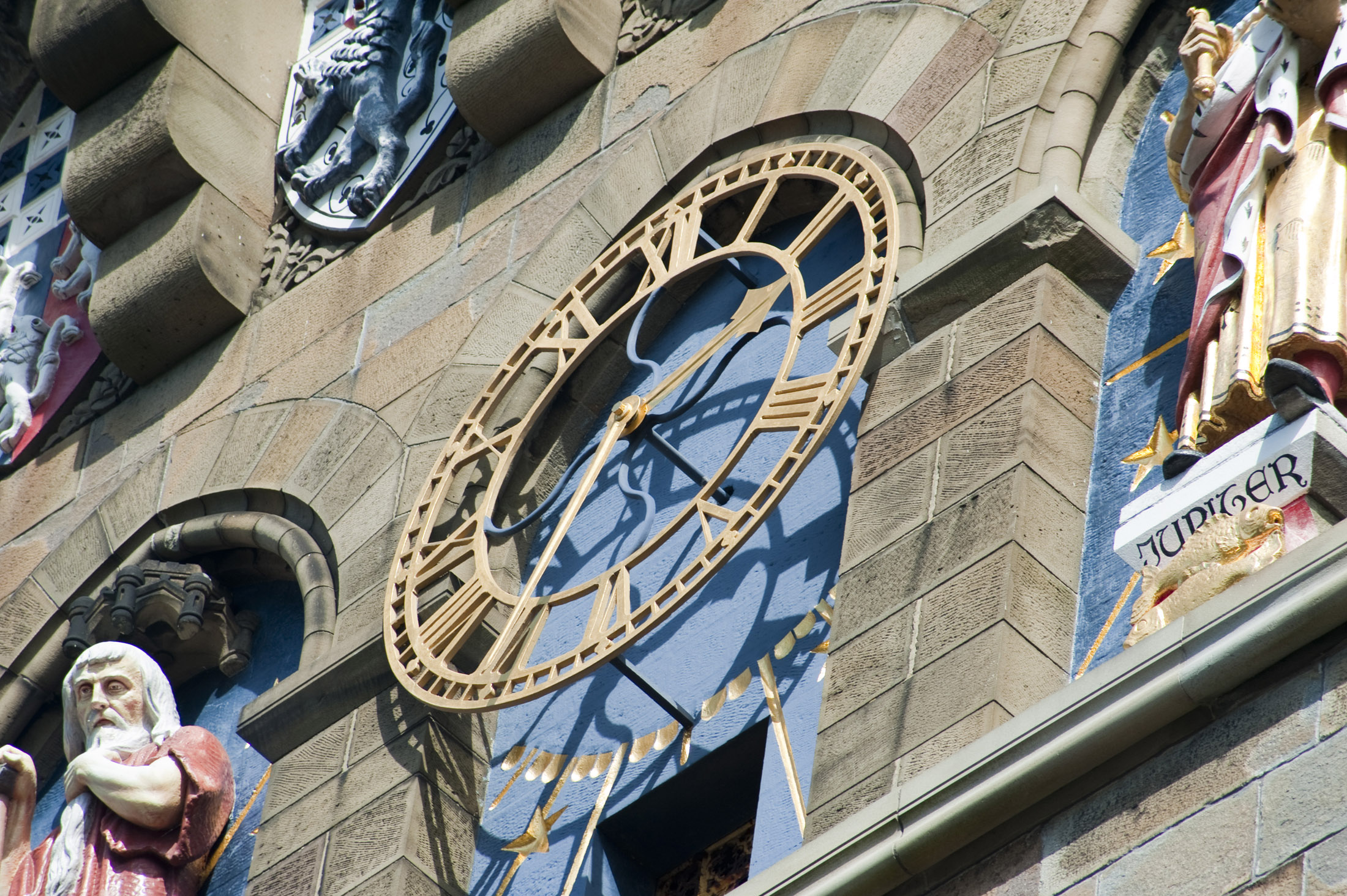 an image of close up on the clock face and statues on cardiff castles clock tower