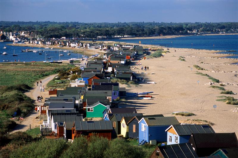 line of beach huts on the mudeford sand spit, christchurch harbour, dorset