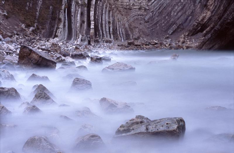 long exposure image of water lapping rocks in stair hole, dorset.