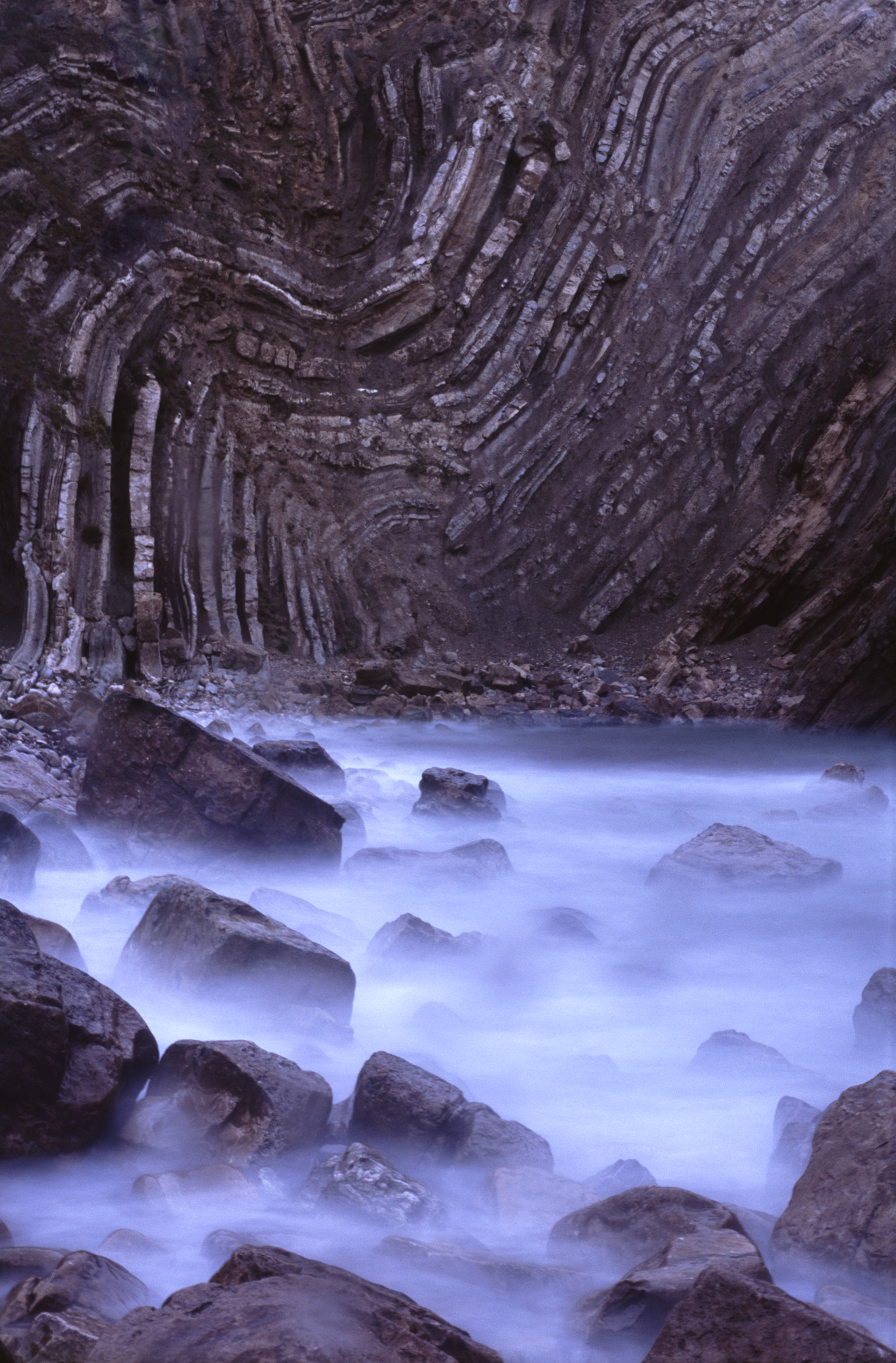 an image of long expose image of water and contorted rock layers on the jurassic coast