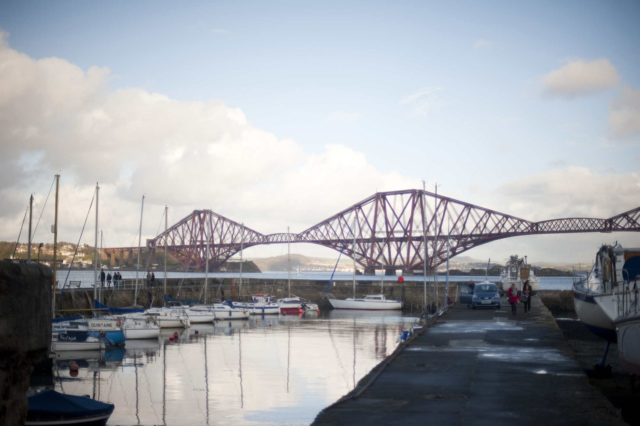 an image of boats in the harbour with the iconic forth rail bridge in the background, queenferry, scotland