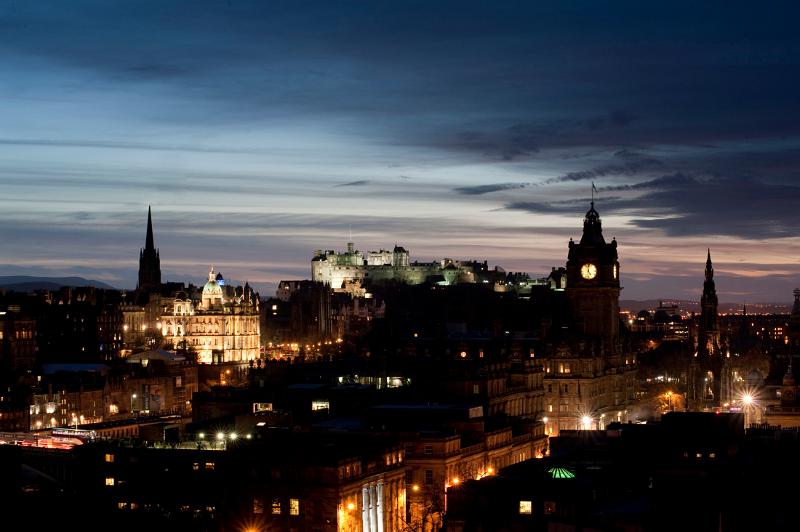 Silhouetted and floodlight shapes of the edinburgh skyline looking towards the castle from carlton hill
