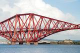 a train dwarfed by the giant structure of the forth bridge, firth of forth, scotland