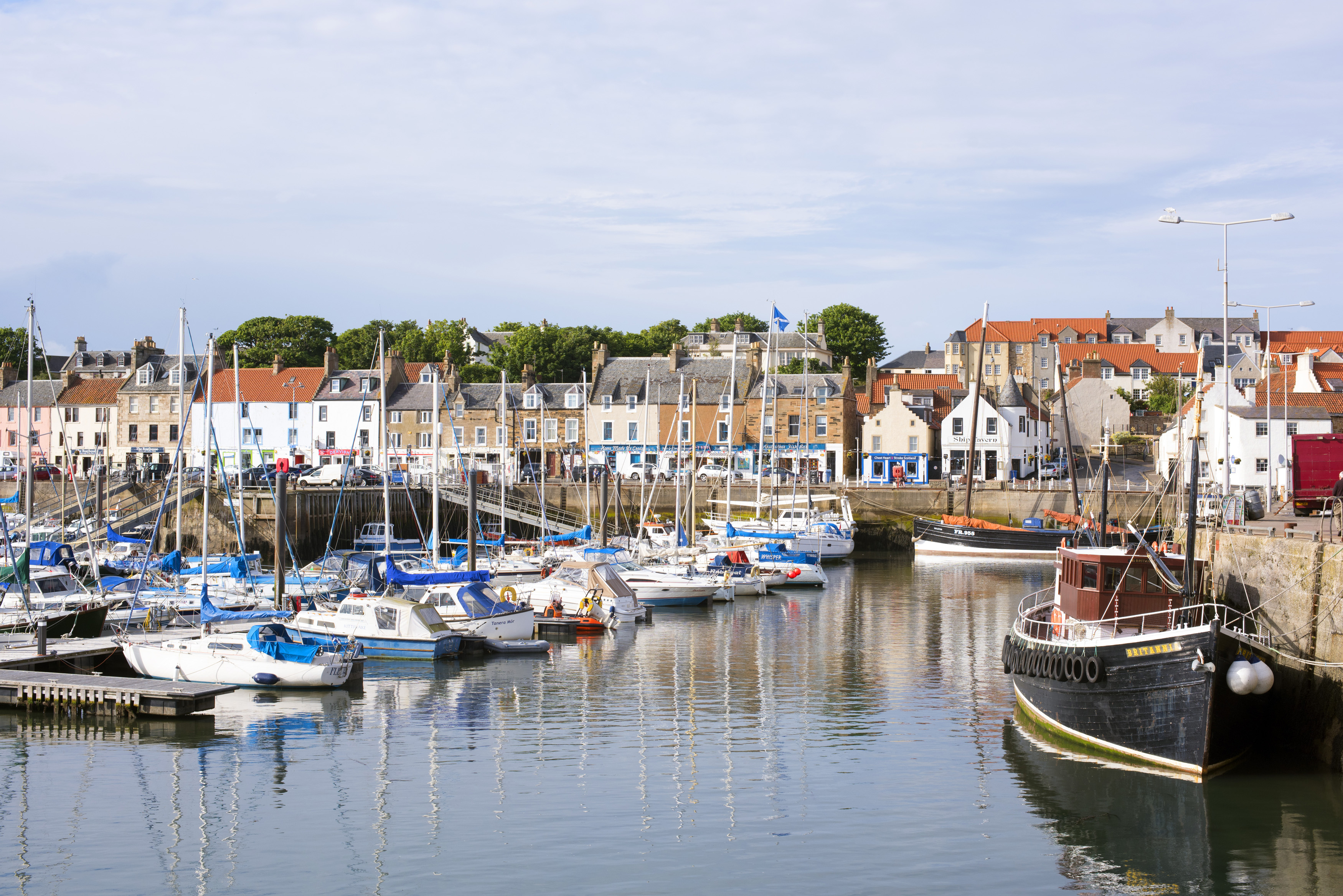 an image of Picturesque view of a tranquil Anstruther harbour on the Fife coast in Scotland with moored yachts, pleasure and fishing boats