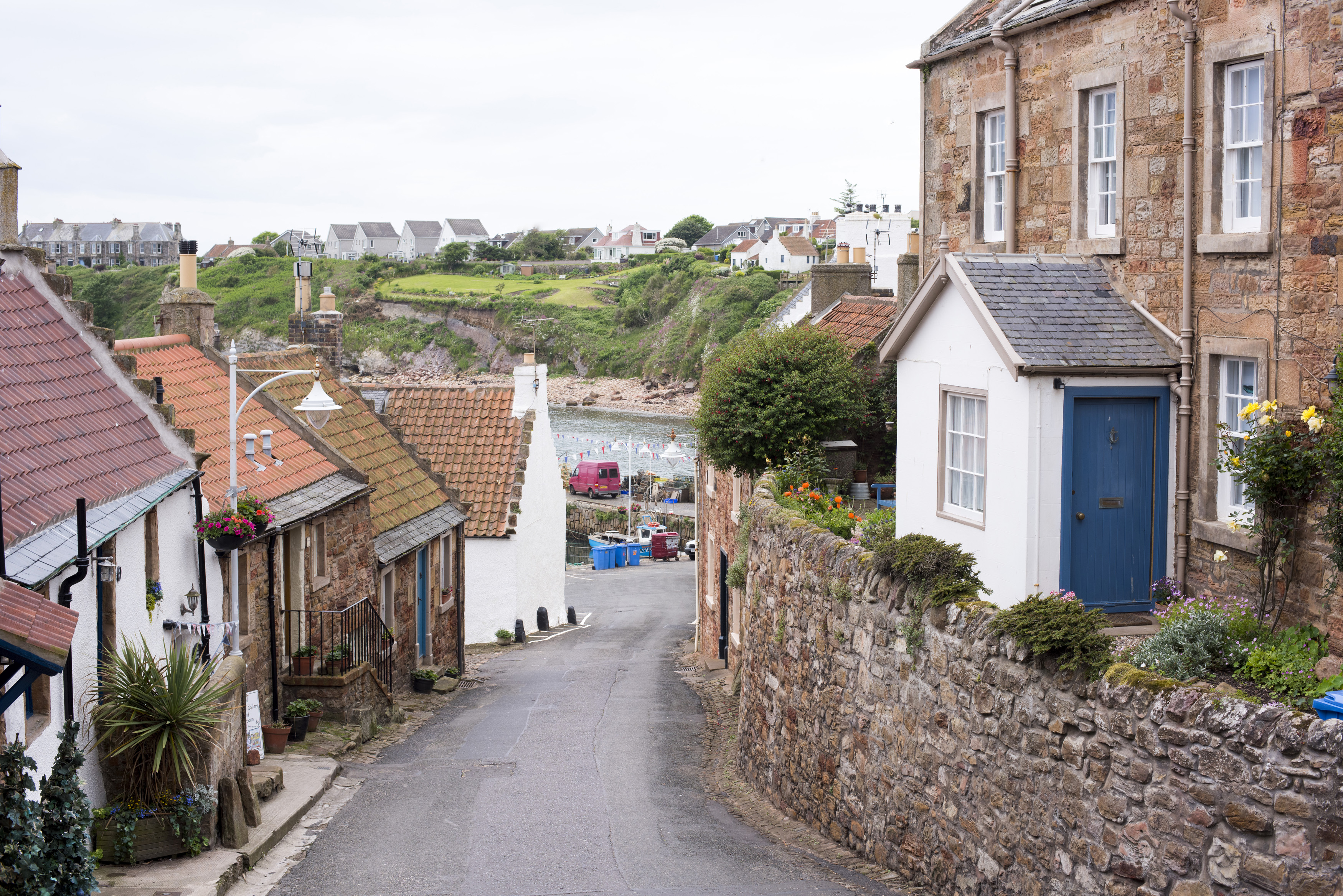 an image of Narrow lane down to the waterfront, Crail, Fife Coast, Scotland, lined with quaint cottages in a scenic landscape view