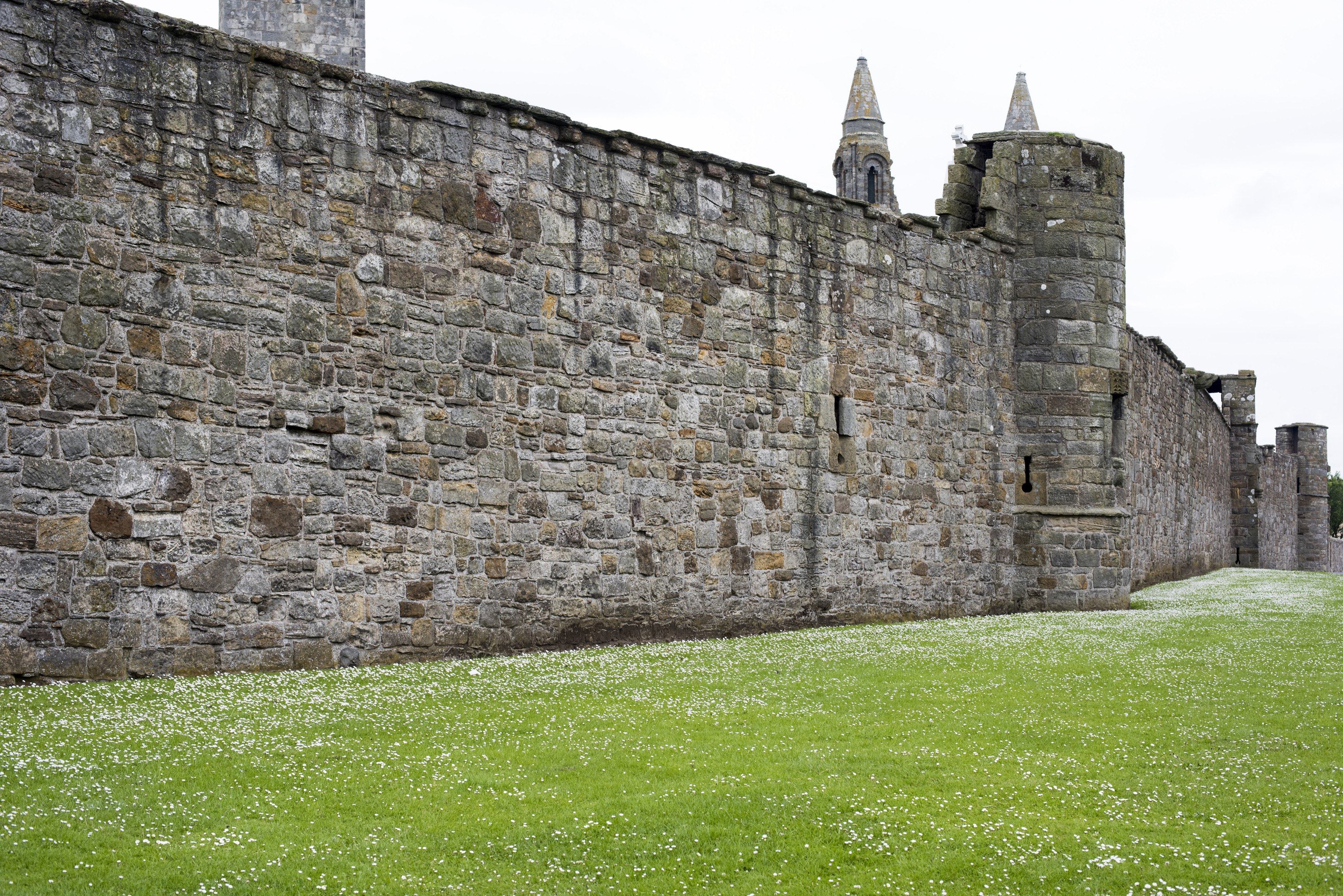 an image of Ancient stone wall of the walled grounds of the St Andrews Cathedral ruins in the Scottish town of St Andrews in a receding perspective