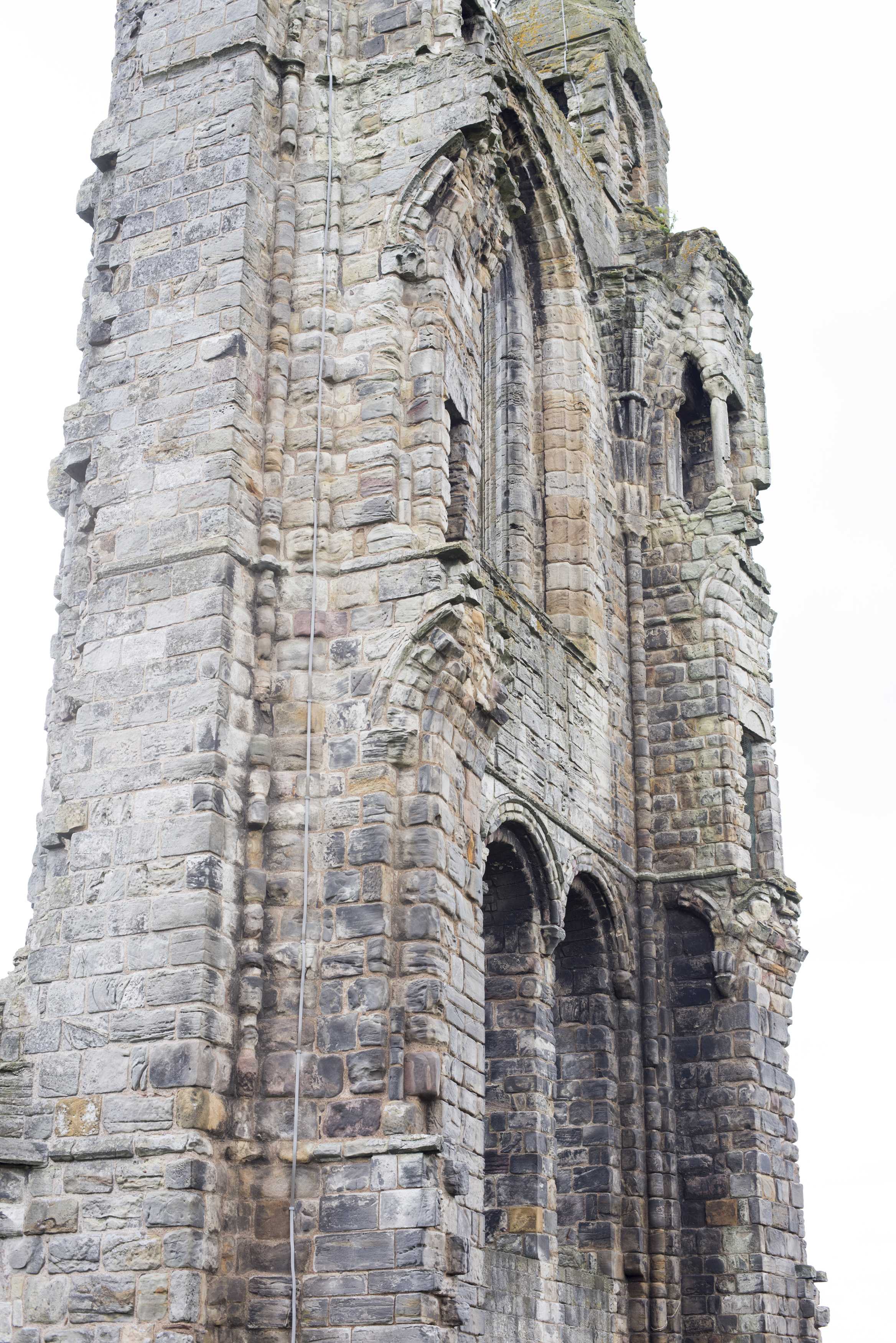 an image of Tall stone ruins with arched entryway and windows as seen from a low angle view