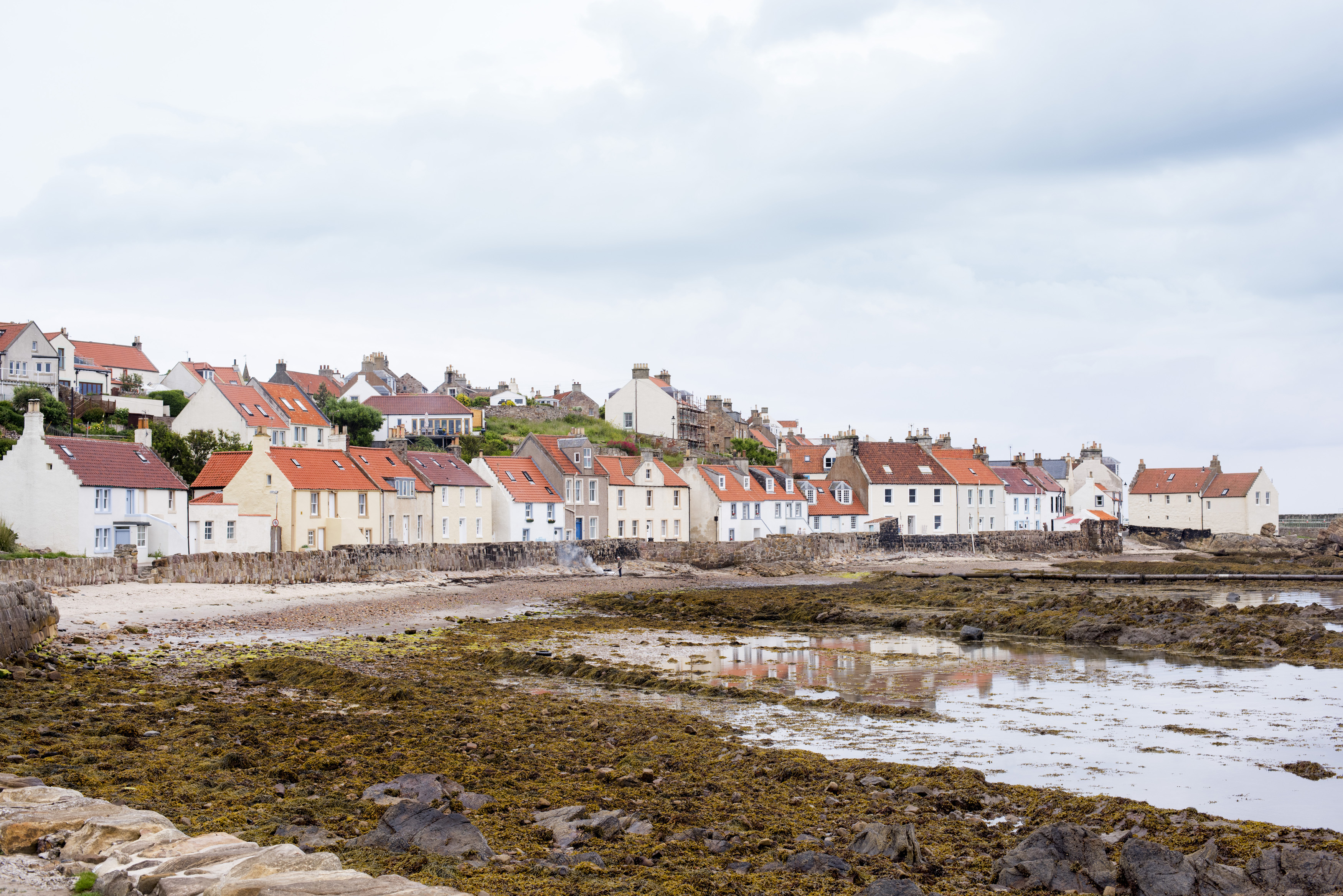 an image of Waterfront at Pittenweem, Fife Coast, Scotland at low tide with the quaint fishermens cottages overlooking the beach and water