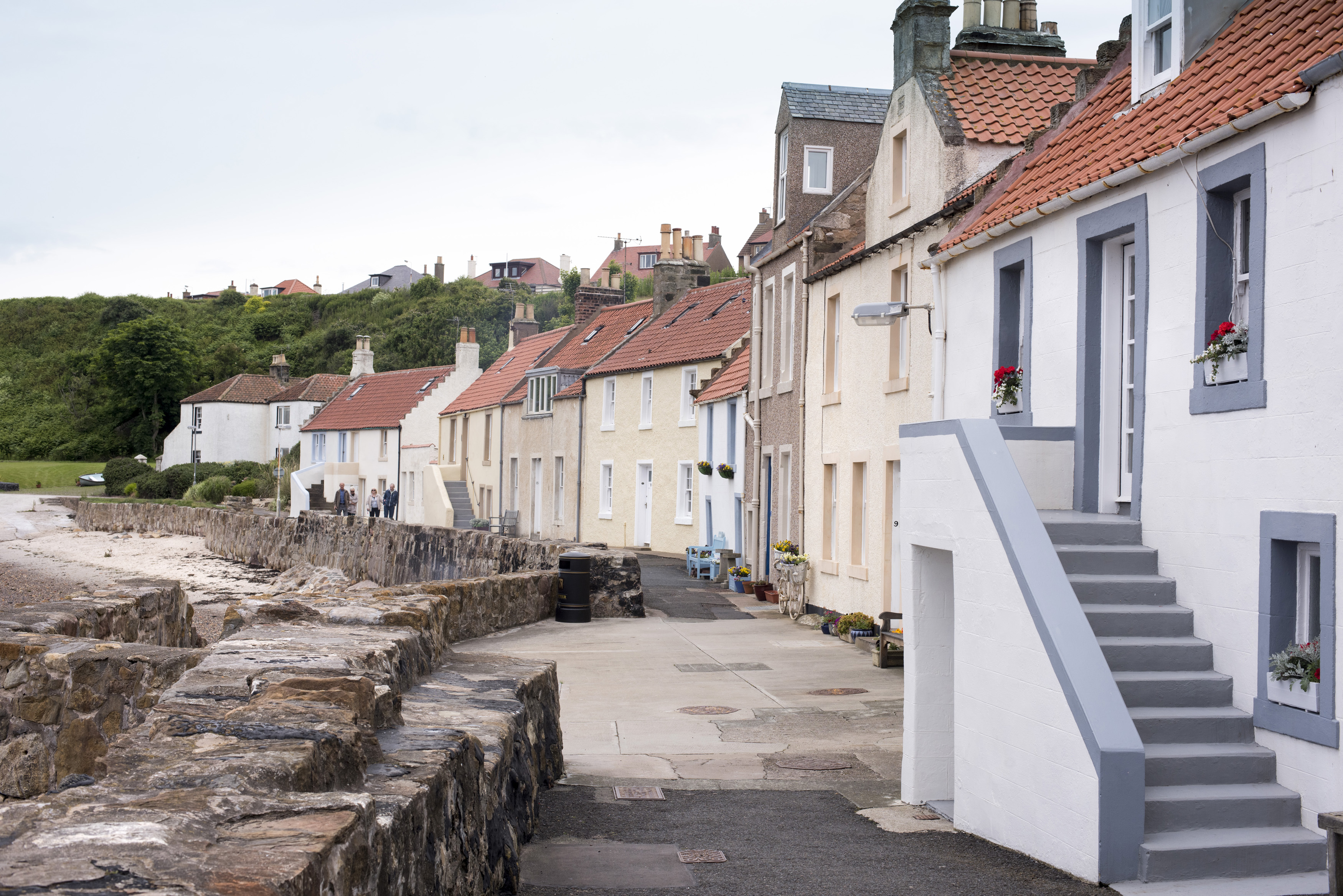 an image of Large boulder seawall in front of historic old beach area houses at Pittenweem, Scotland