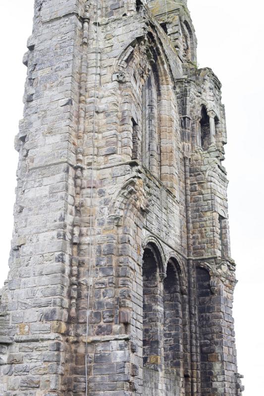 Tall stone ruins with arched entryway and windows as seen from a low angle view