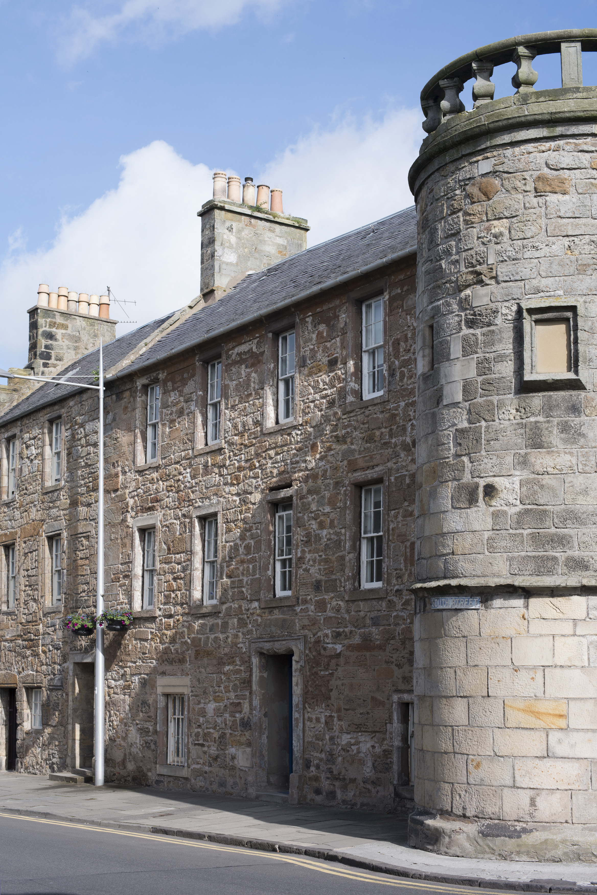 an image of Street level view on round corner of stone block building in Saint Andrews, Scotland