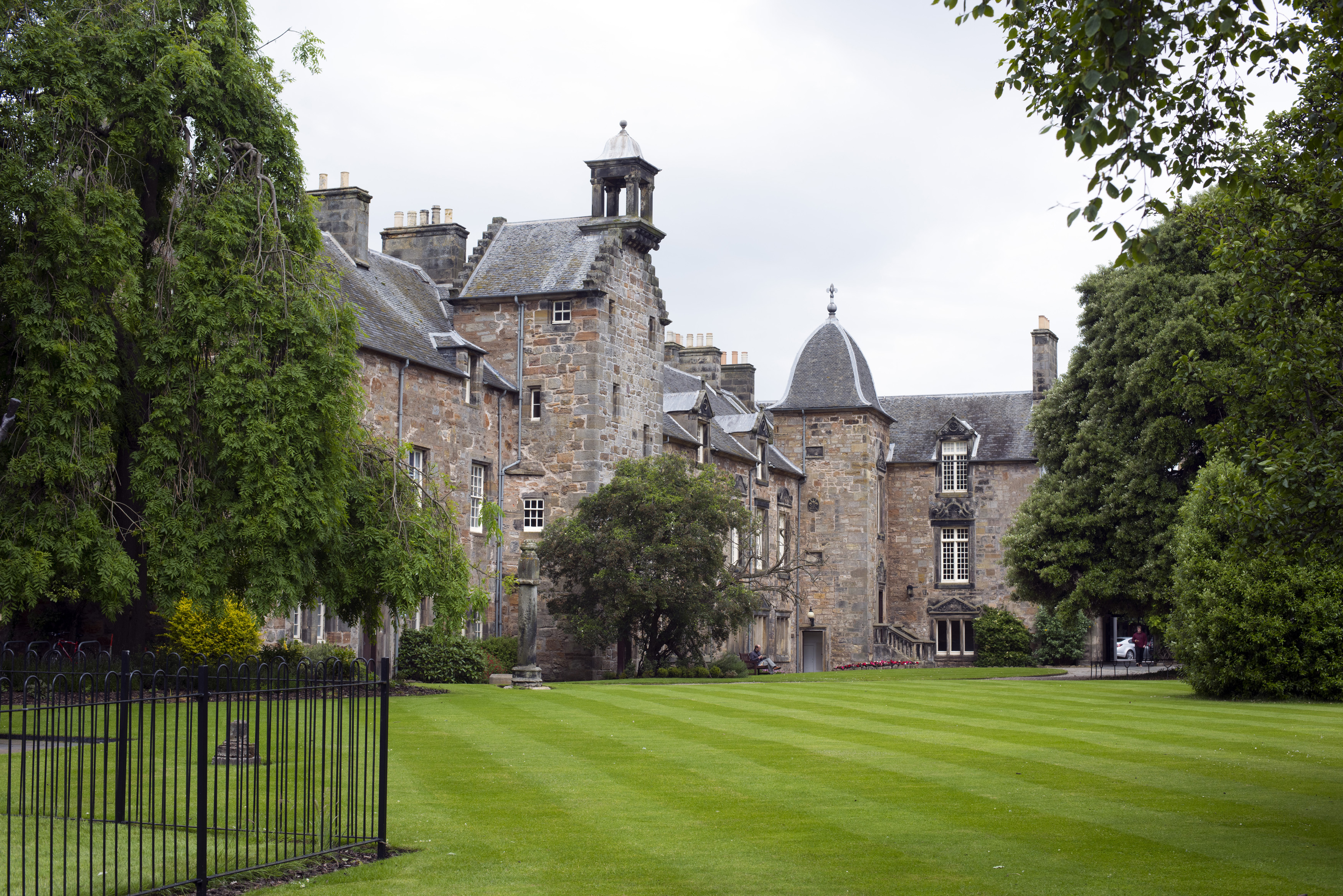 an image of Grounds of St Andrews University, Scotland looking across manicured green lawns to historic stone buildings