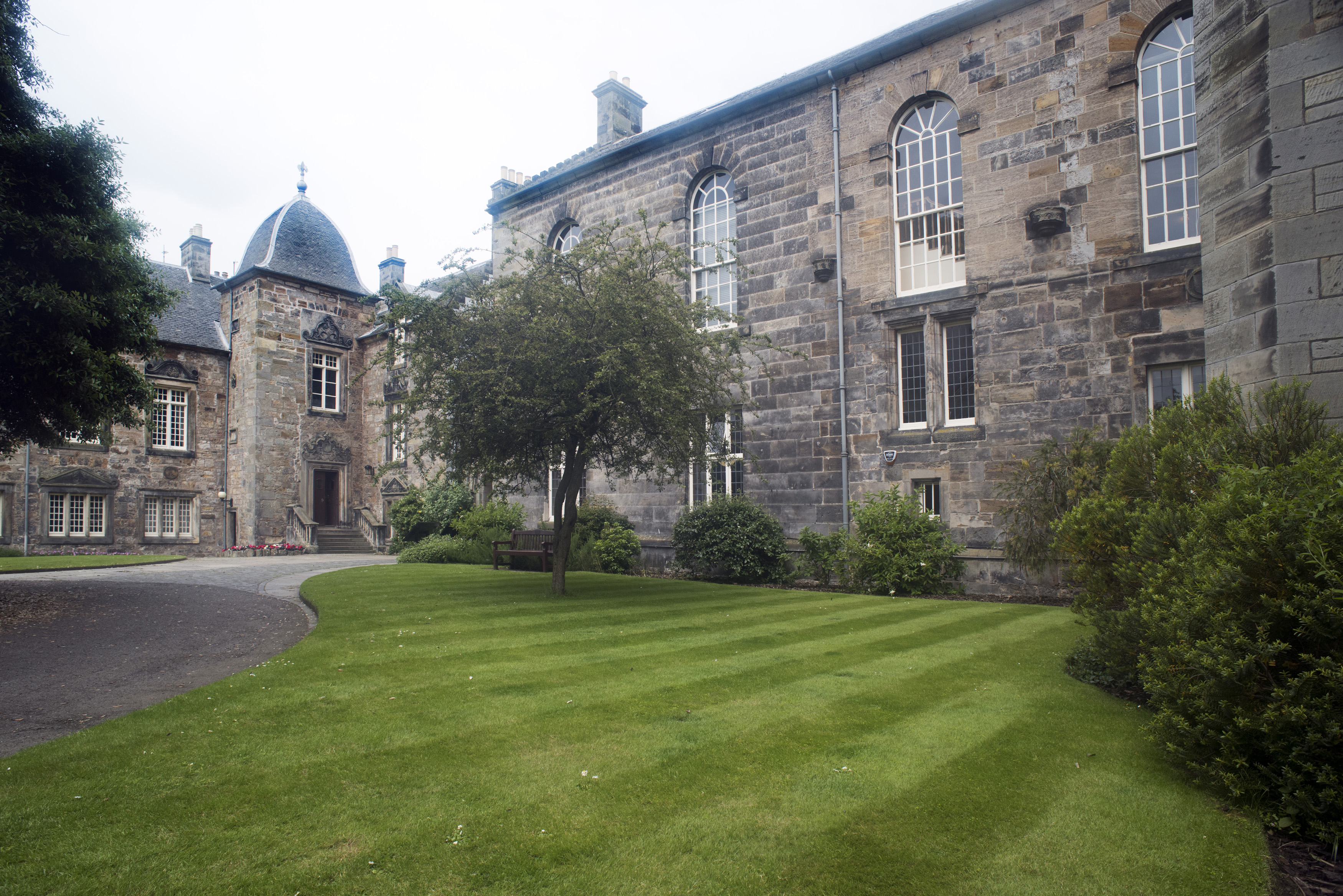 an image of Grounds and historic buildings of St Andrews University, Scotland showing manicured lawns and old stone architecture with graceful arched windows
