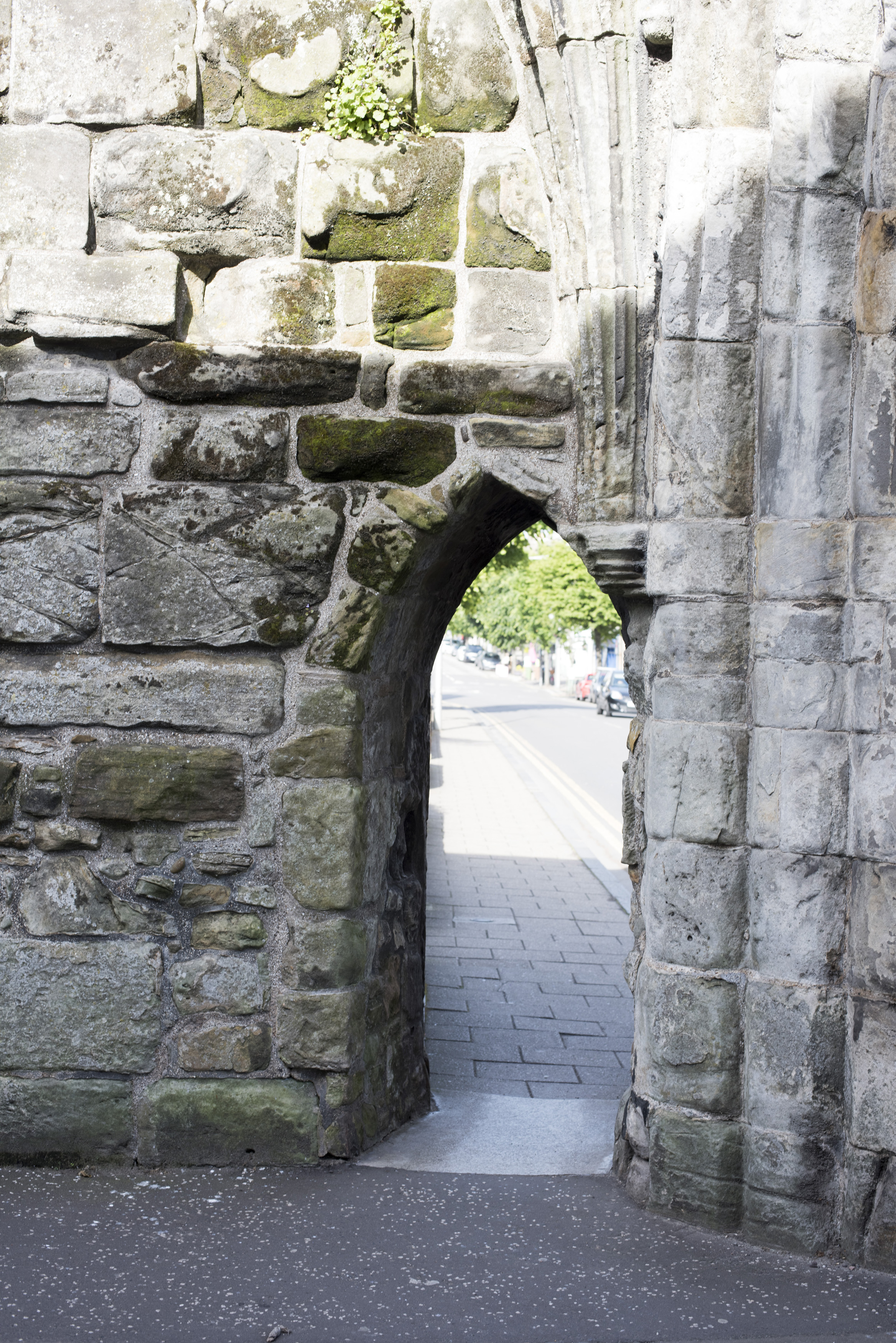 an image of Old weathered and mossy stone arch doorway in ruins of church in St Andrews, Scotland