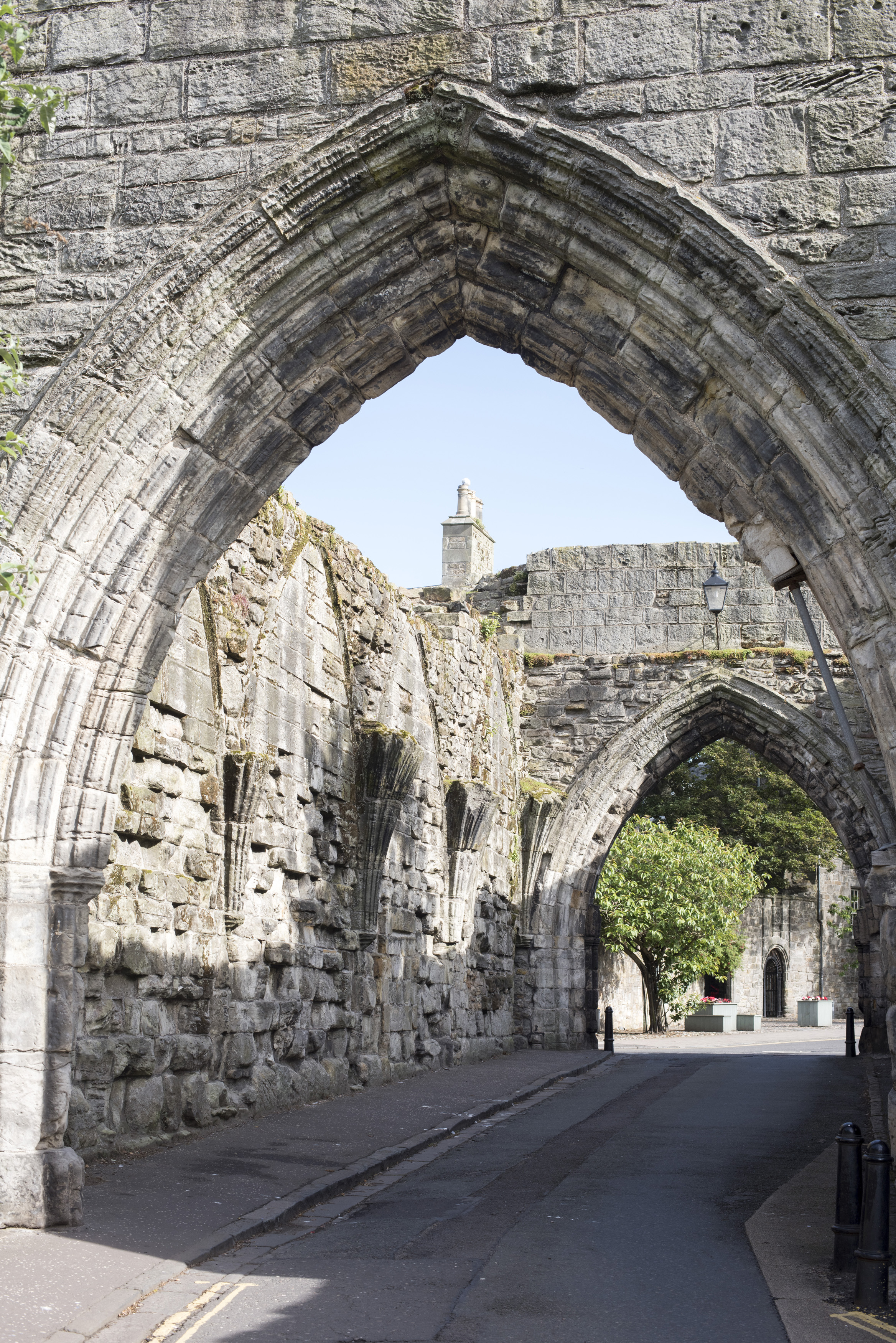 an image of Old Medieval stone entrance arch, St Andrews, Scotland with a narrow road passing underneath to the second arch in a travel and tourism concept
