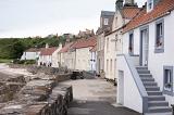 Large boulder seawall in front of historic old beach area houses at Pittenweem, Scotland