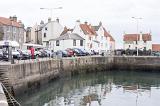 Cars and vans belonging to tourists parked around empty harbor at Pittenweem, Scotland