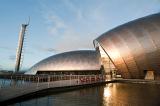 View of the distinctive curved metal clad exterior of the Glasgow Science Centre in the Princes Dock Development reflected in the water of the Clyde River