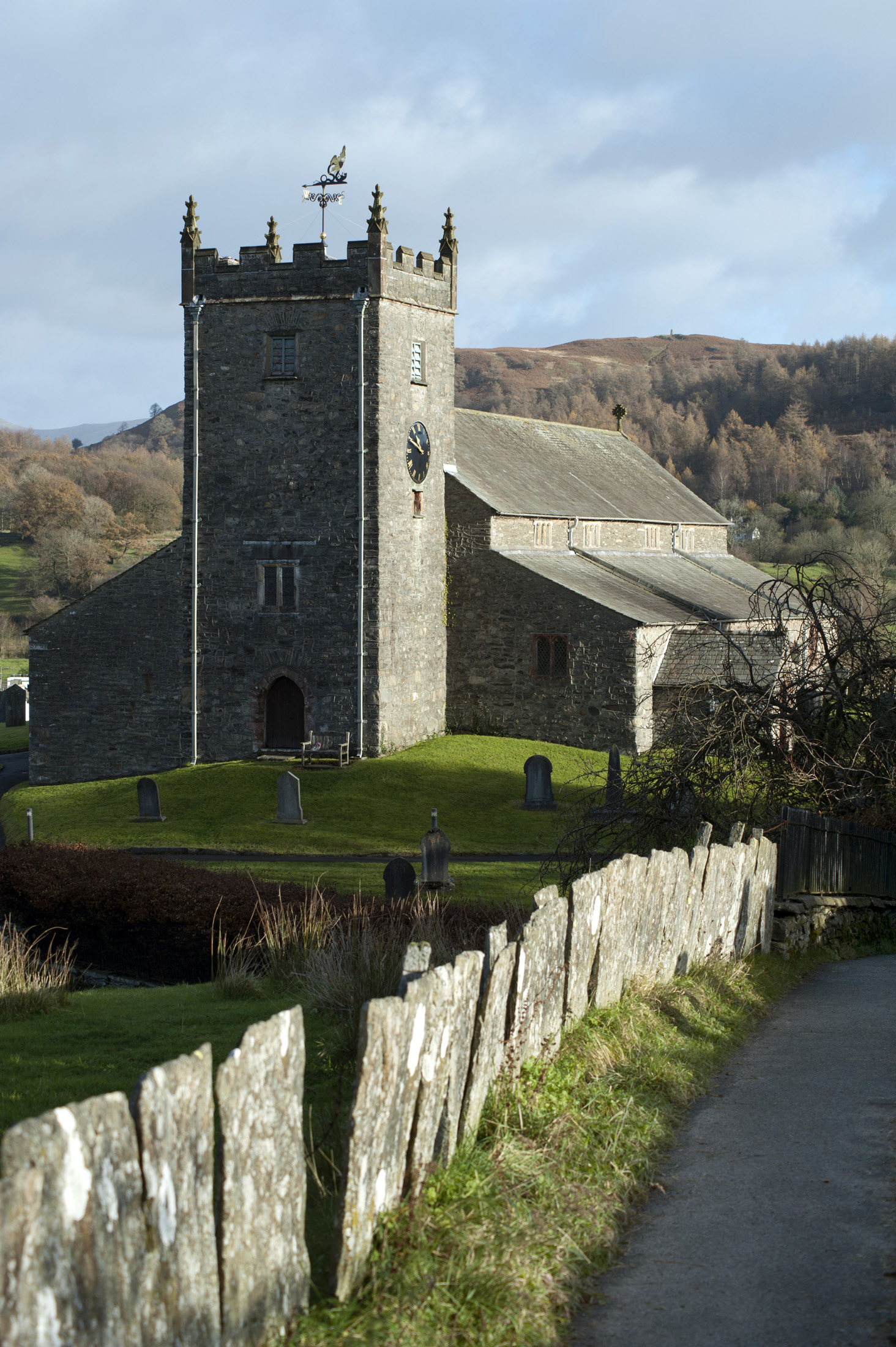 an image of View down a country lane of Hawkshead church in the picturesque village of Hawkshead in the English Lake District in Cumbria and a popular tourist destination