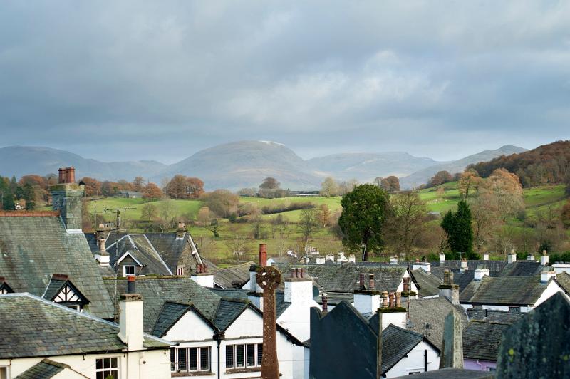 Panoramic view of Hawkshead in Cumbria with its picturesque whitewashed cottages surrounded by lush countryside with mountins and rolling hills, a popular tourist destination in the Lake District