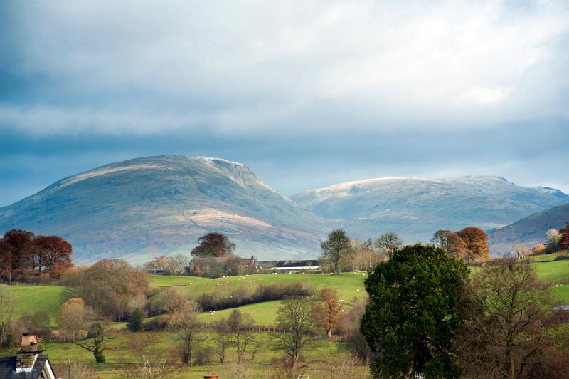 Red Screes, English Lake District, Cumbria a scenic fell or mountain viewed across lush wooded countryside on a cloudy day