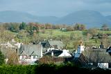View over the rooftops of the whitewashed cottages of Hawkshead village to Red Screes in the English Lake District in Cumbria