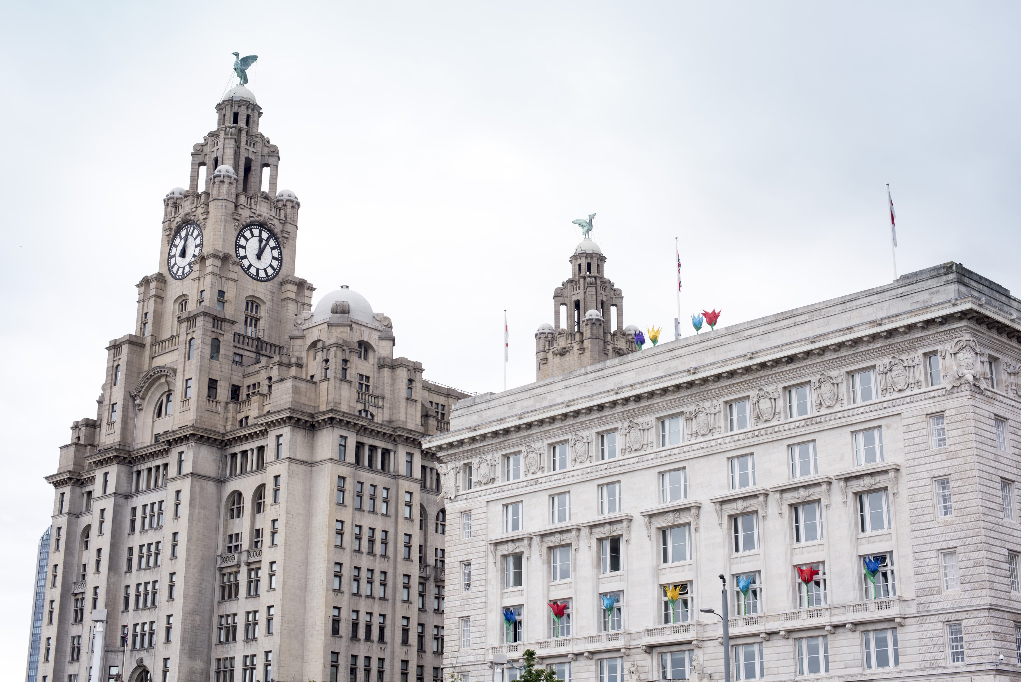an image of Liverpool Liver Building with famous clock tower and statues on top in the United Kingdom under overcast sky