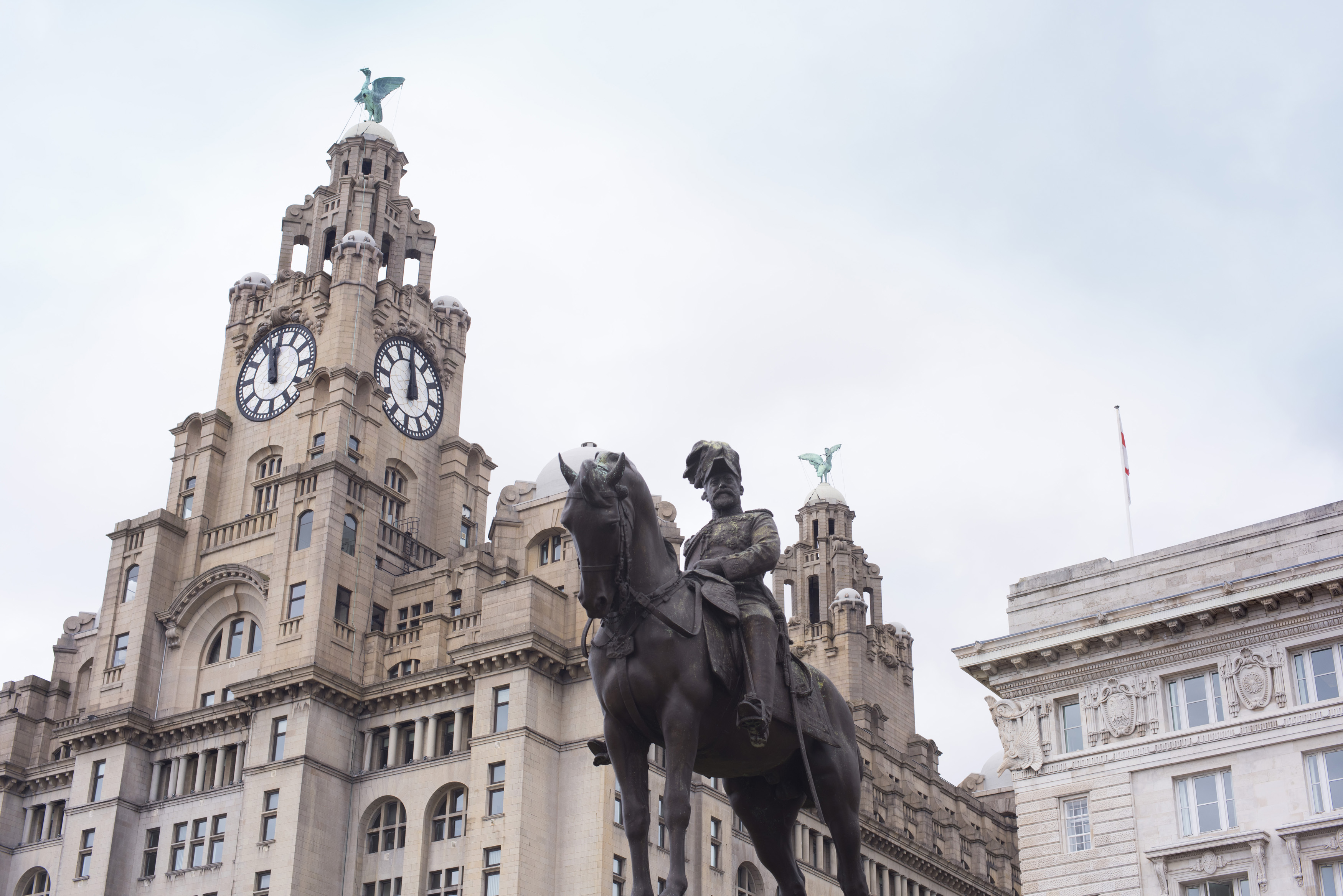 an image of Low angle view on statue of Edward the VII near Liver Building in downtown Liverpool, United KIngdom