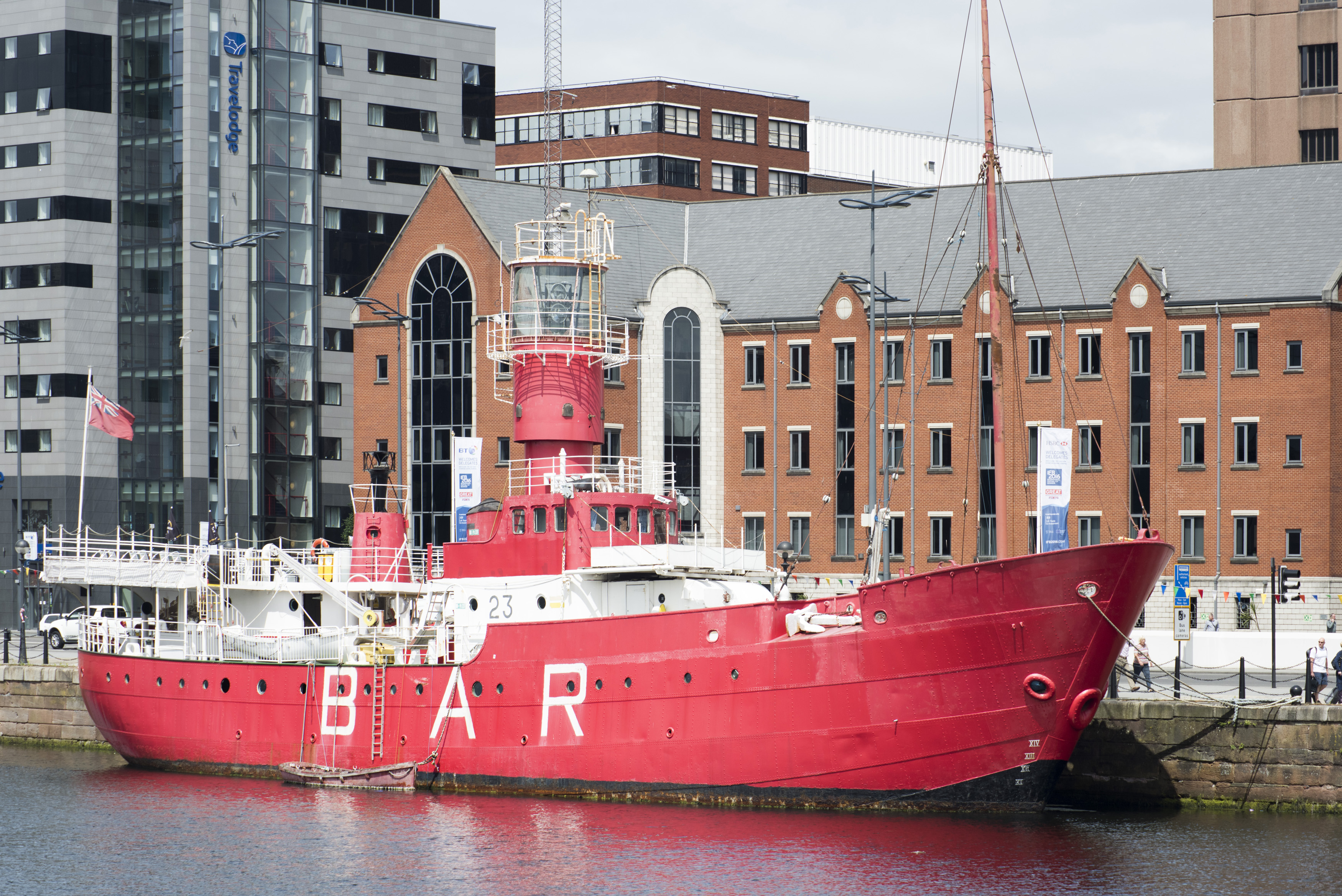 an image of Large red light boat BAR moored at dock in Liverpool waterfront. A popular destination for tourists in the United Kingdom.