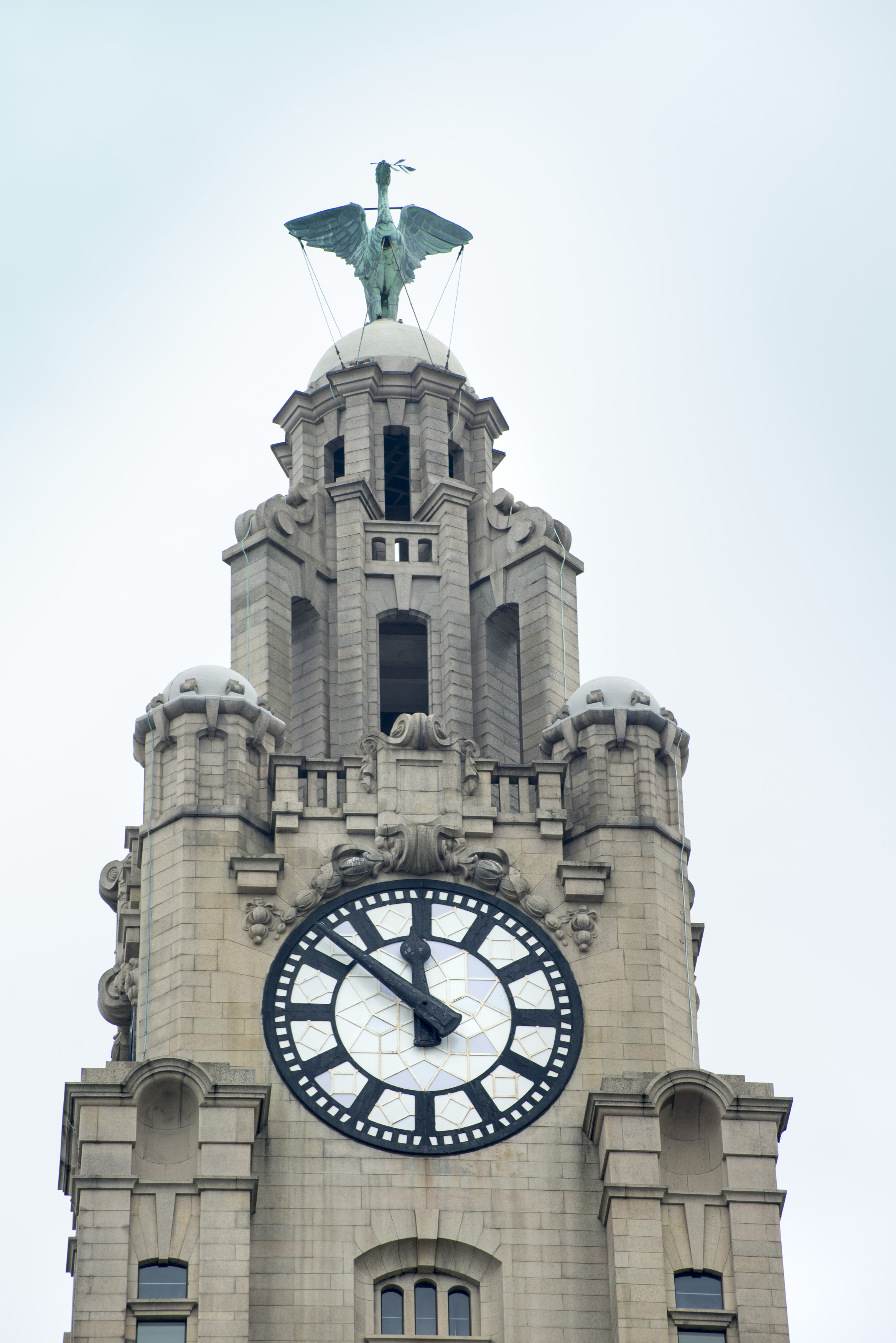 an image of Close up on Liver Building clock tower with statue on top in Liverpool, United Kingdom