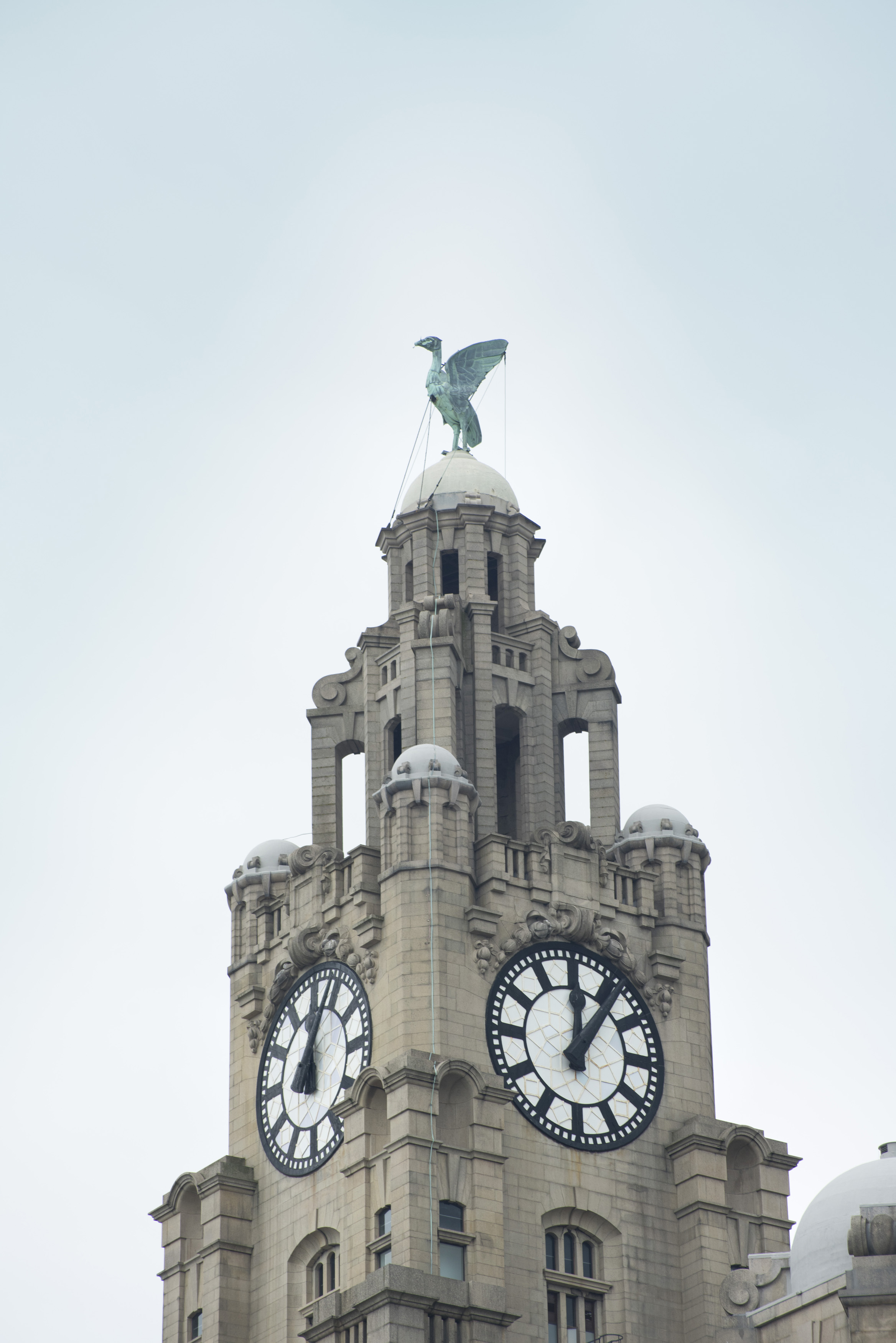 an image of Clock tower on the Liver building, Liverpool, England surmounted by one of the two Liver Birds, a cormorant, wich if it were to fly away would mean the end of the city