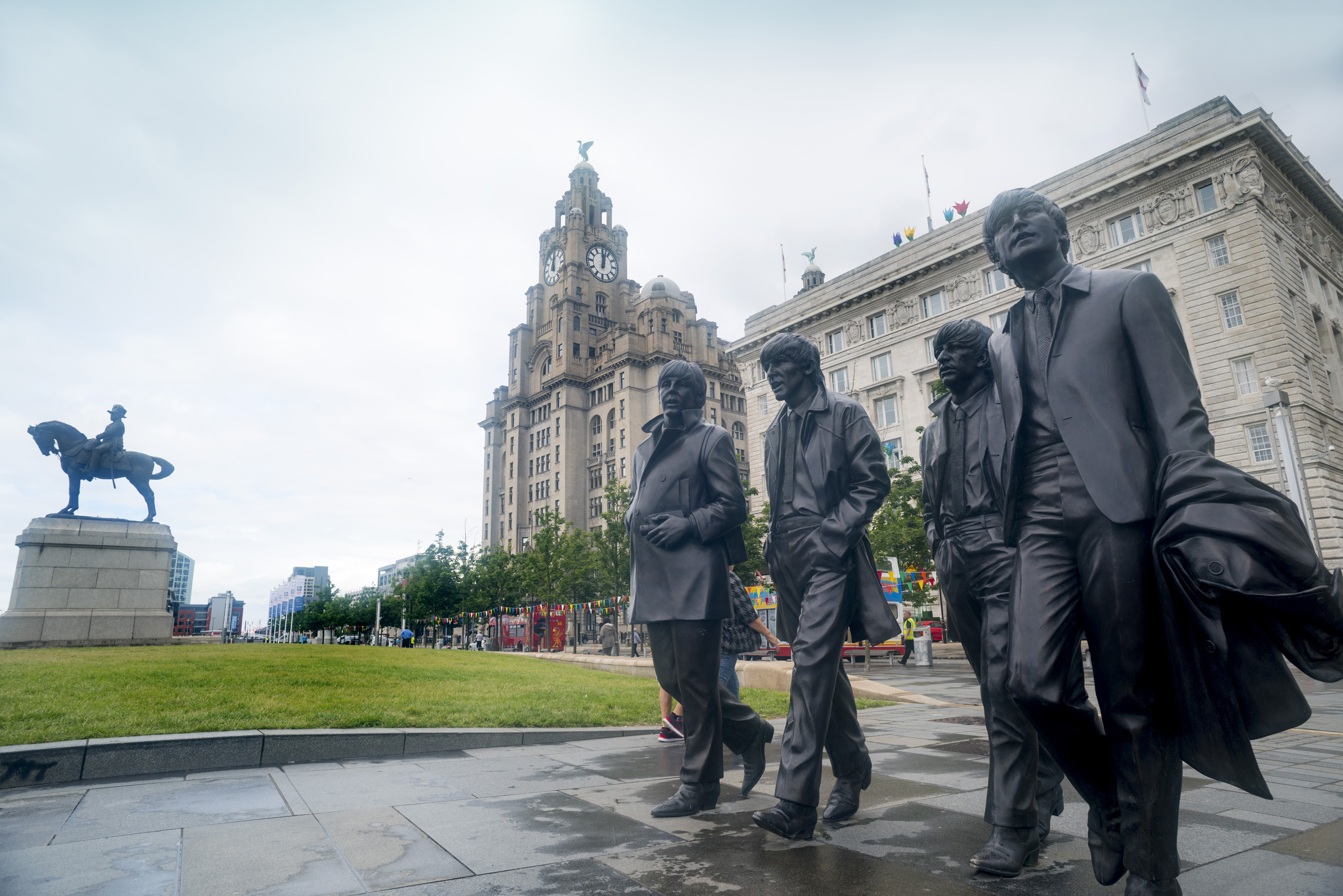an image of Statues of the Beatles walking near the Liver Building in Liverpool, United Kingdom