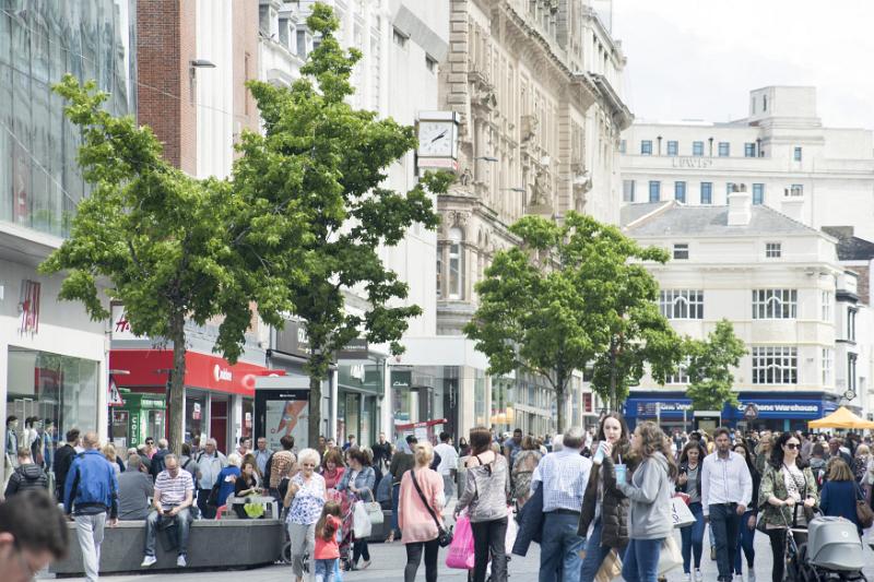 Crowds of various adults and children walking and mingling in Liverpool central shopping district