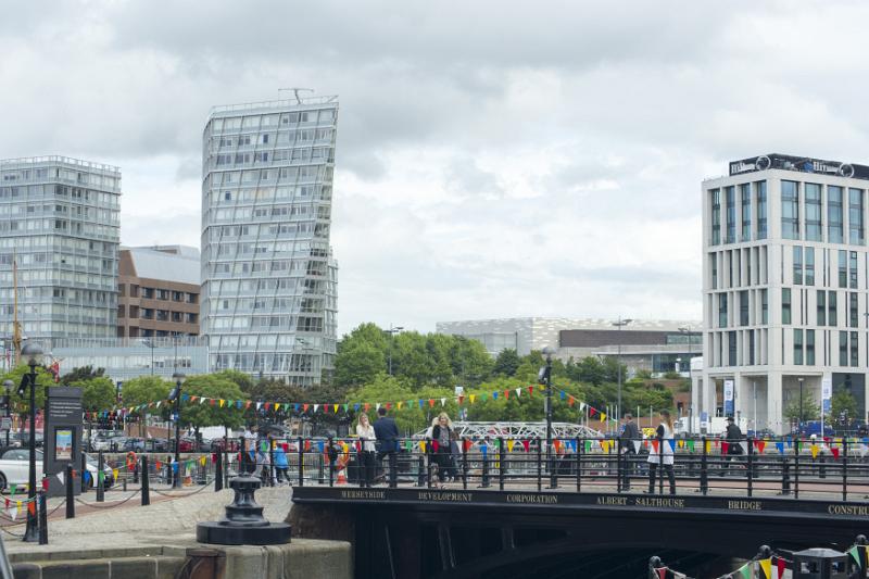Groups of tourists walking over a footbridge at the Liverpool Albert Dock in the United Kingdom