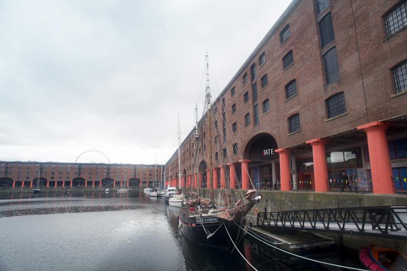 Wide view of boats docked at Liverpool Albert Dock under overcast skies. Includes copy space at top.