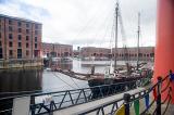 View old fashioned schooner boat from railing beside red columns at the Liverpool Albert Dock in the United Kingdom