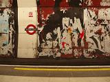 Grungy walls on the platform at the tune station London underground with remnants of posters and advertising and flaking paint