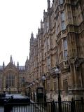 Ornate Gothic revival facade of the Palace of Westminster and Houses of Parliament with a row of streetlamps outside