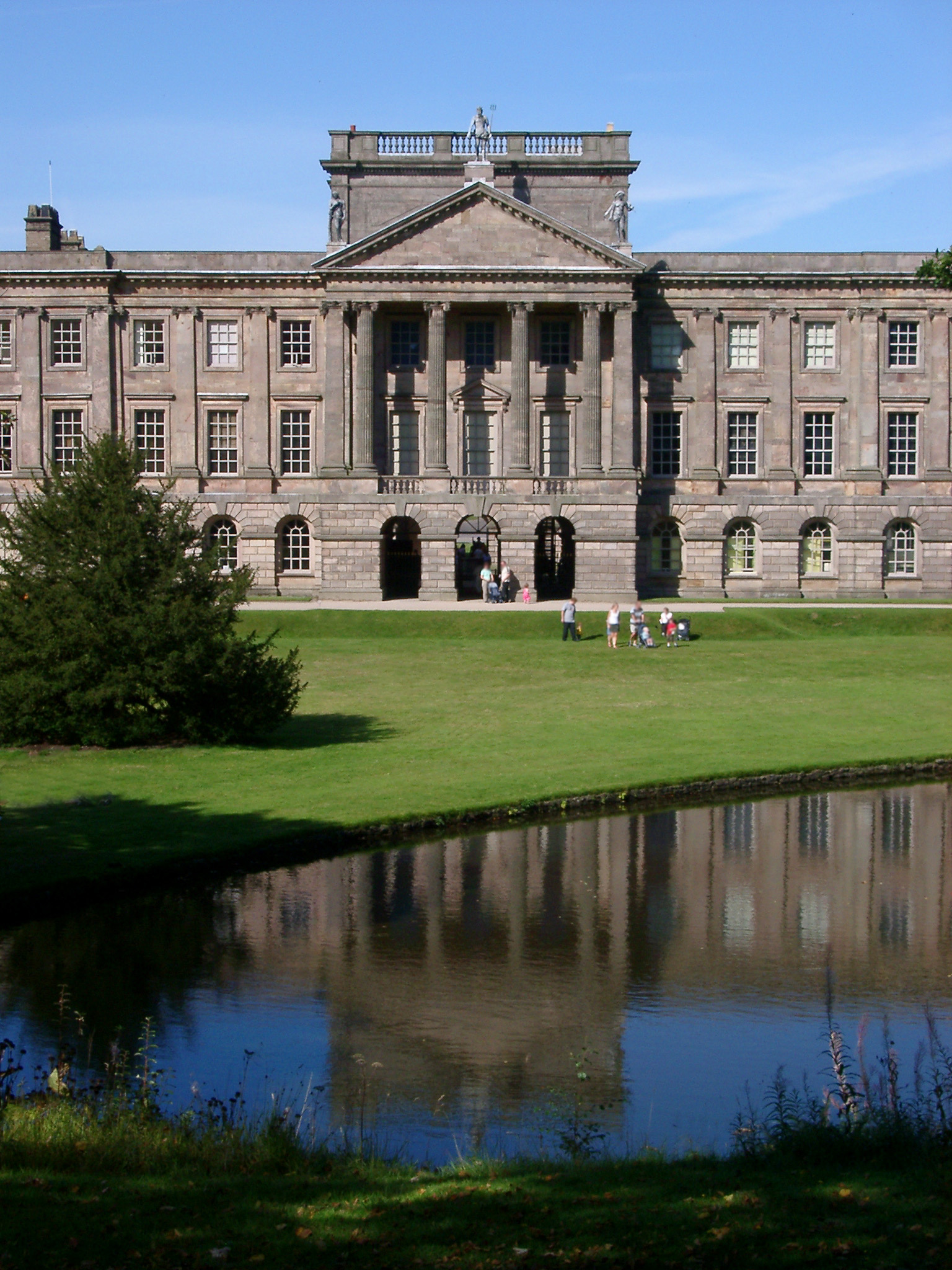 an image of Imposing exterior facade of Lyme Park, a mansion house surrounded by formal gardens, in a deer park in the Peak District National Park