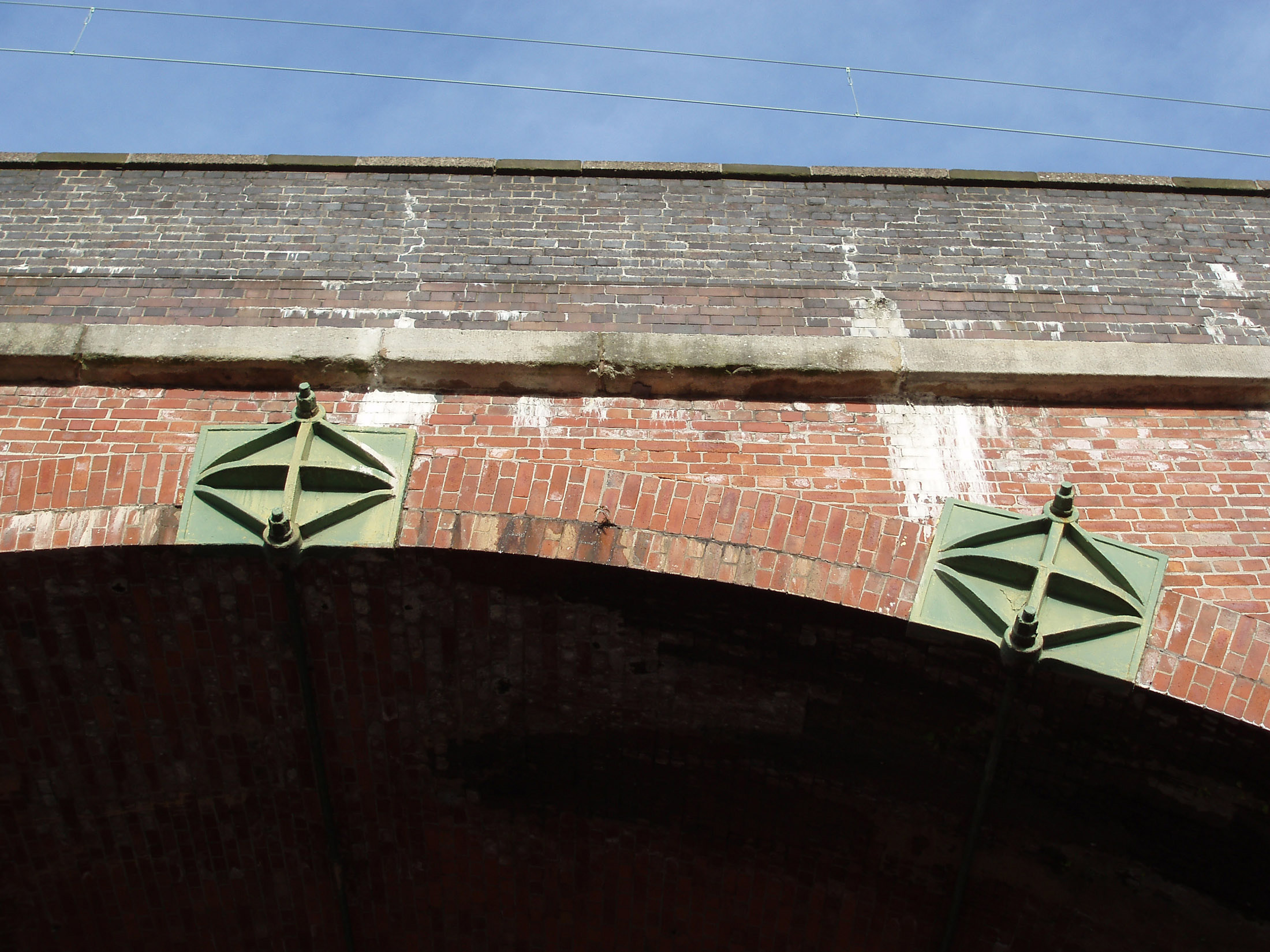 an image of Old brick railway arch on a viaduct at Castlefields, Manchester, Lancashire against a clear sunny blue sky