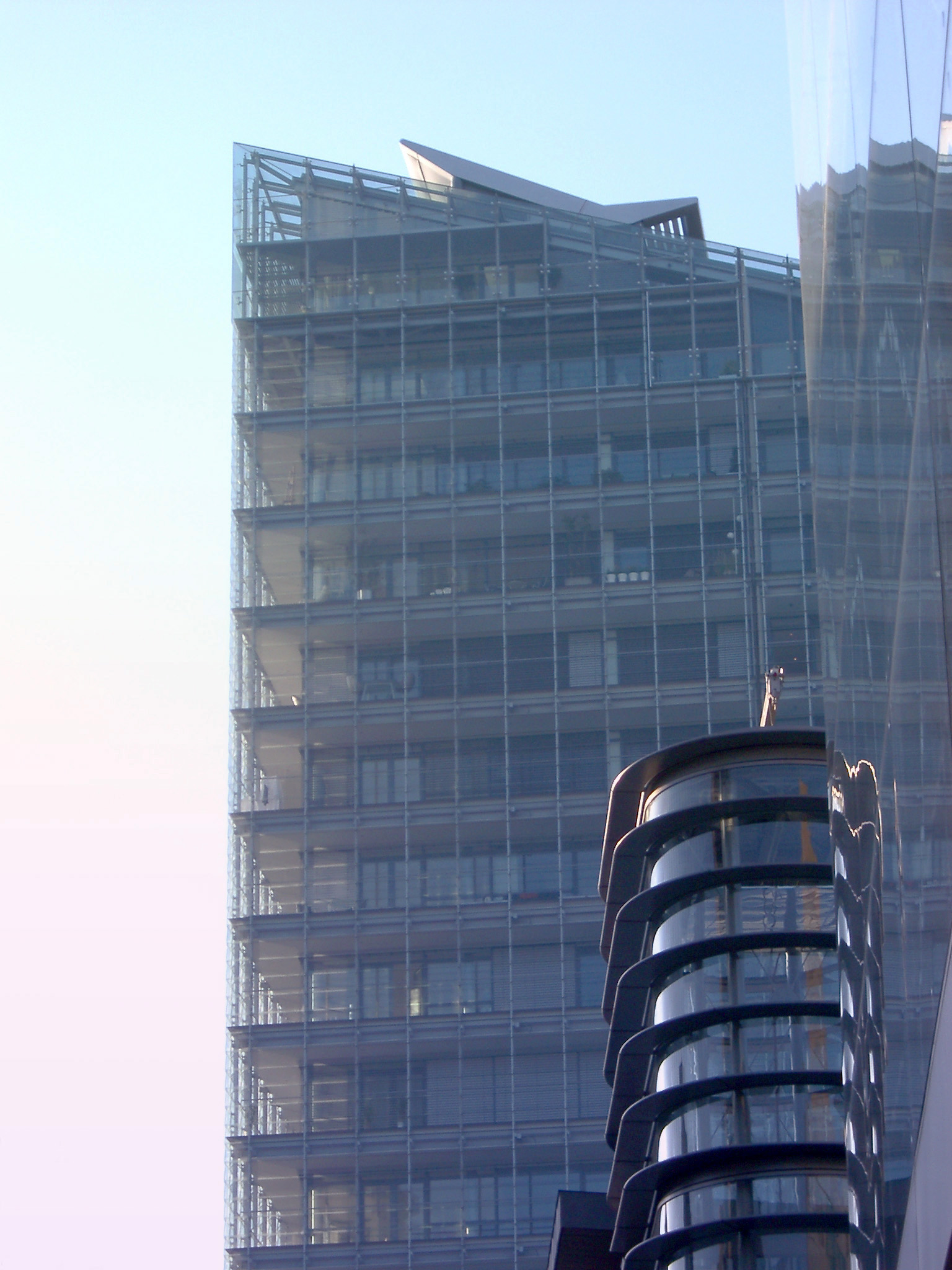 an image of Modern City Building with Glass Walls at Manchester, England on Very Light Blue Sky Background.