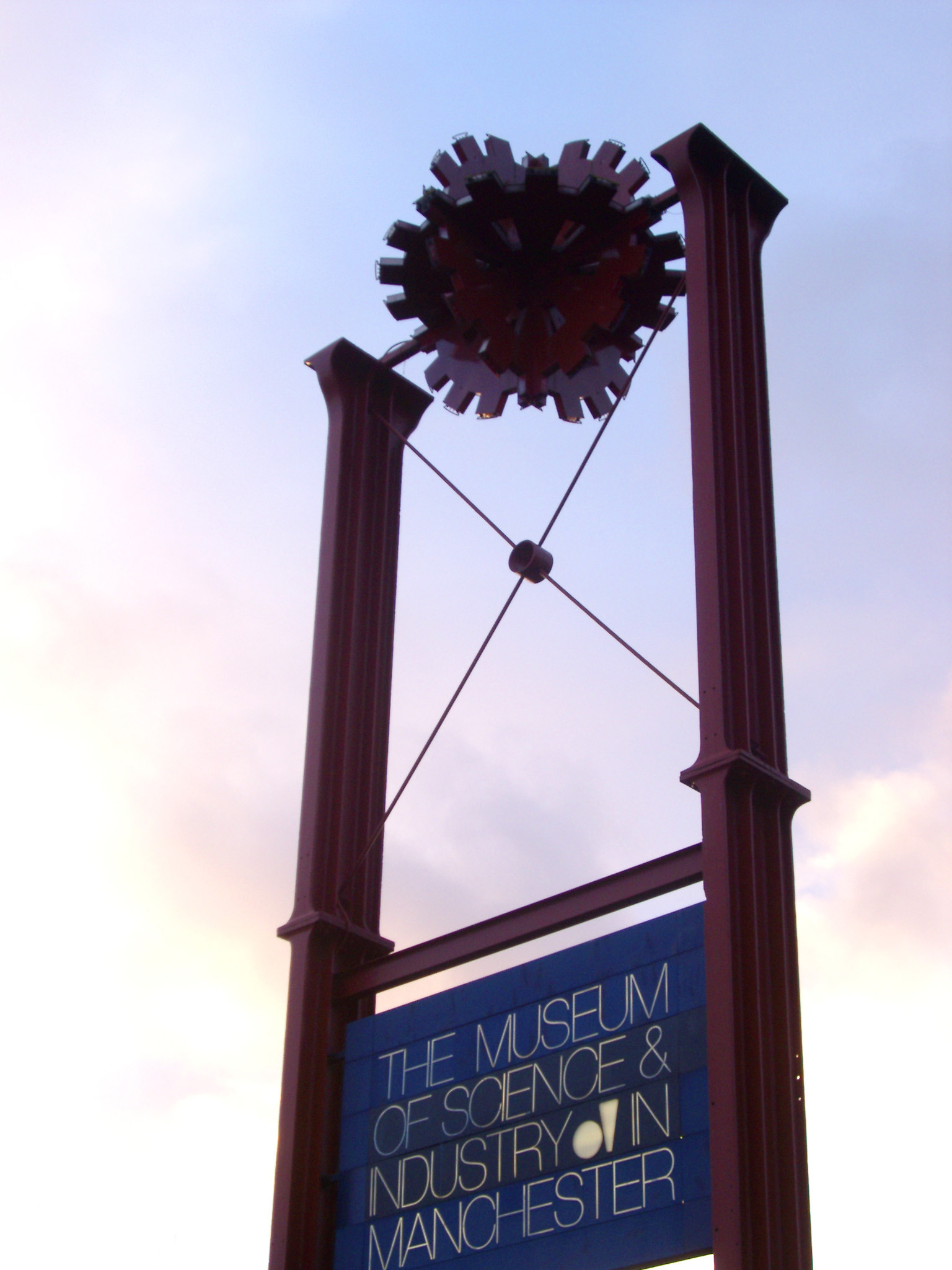 an image of Museum sign board for the Museum of Science and Industry in Manchester silhouetted against a cloudy blue sky