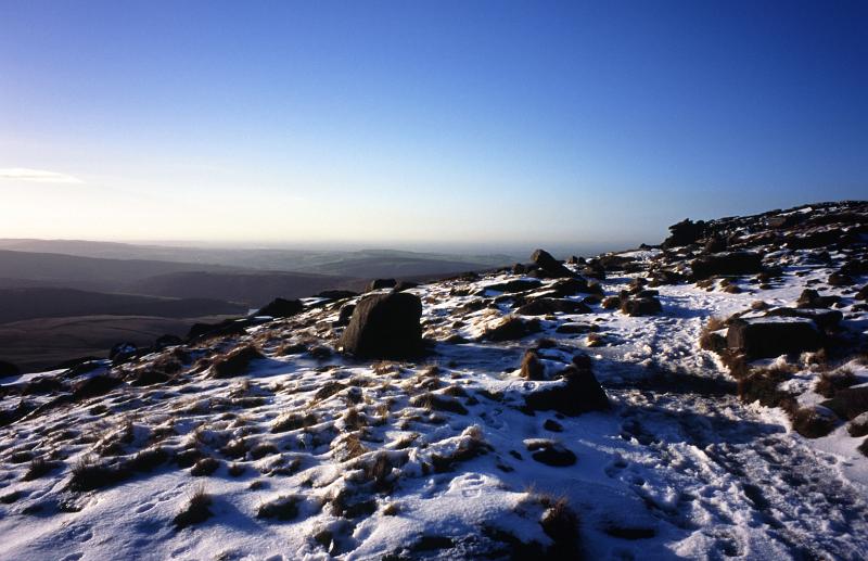 Winter hiking on Kinder Scout, a moorland plateau and National Nature Reserve in the Dark Peak of the Derbyshire Peak District in England