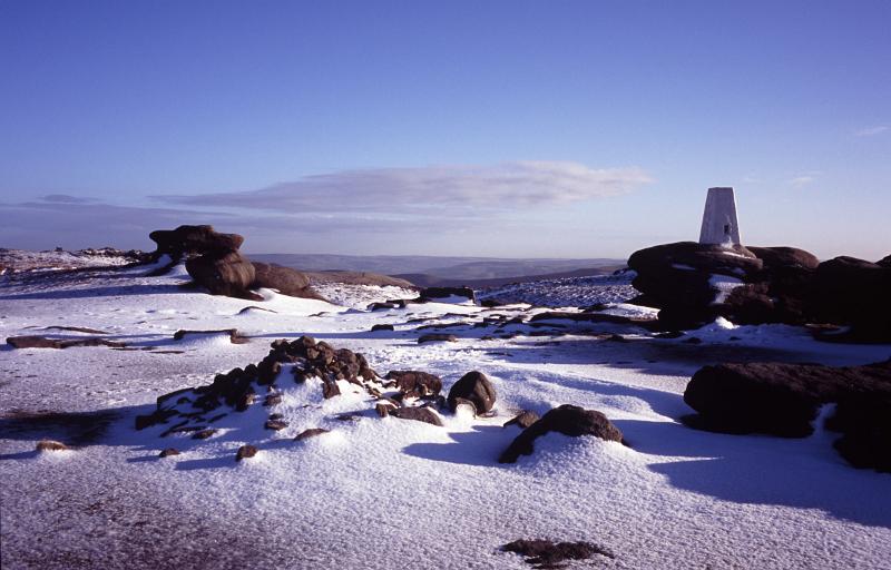 Picturesque view of the Kinder Scout moorlands in winter snow under a sunny crisp blue sky