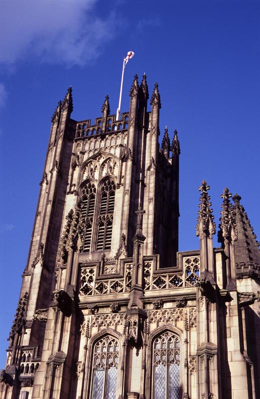 Exterior View of Upper Part of Historic Manchester Cathedral in England, United Kingdom. Captured with Light Blue Violet Sky Background.