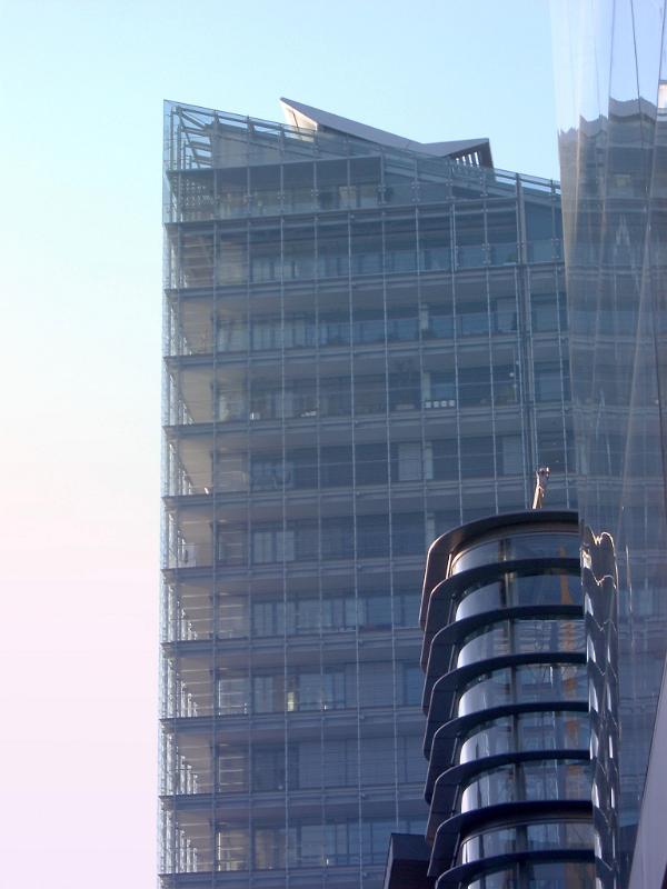 Modern City Building with Glass Walls at Manchester, England on Very Light Blue Sky Background.